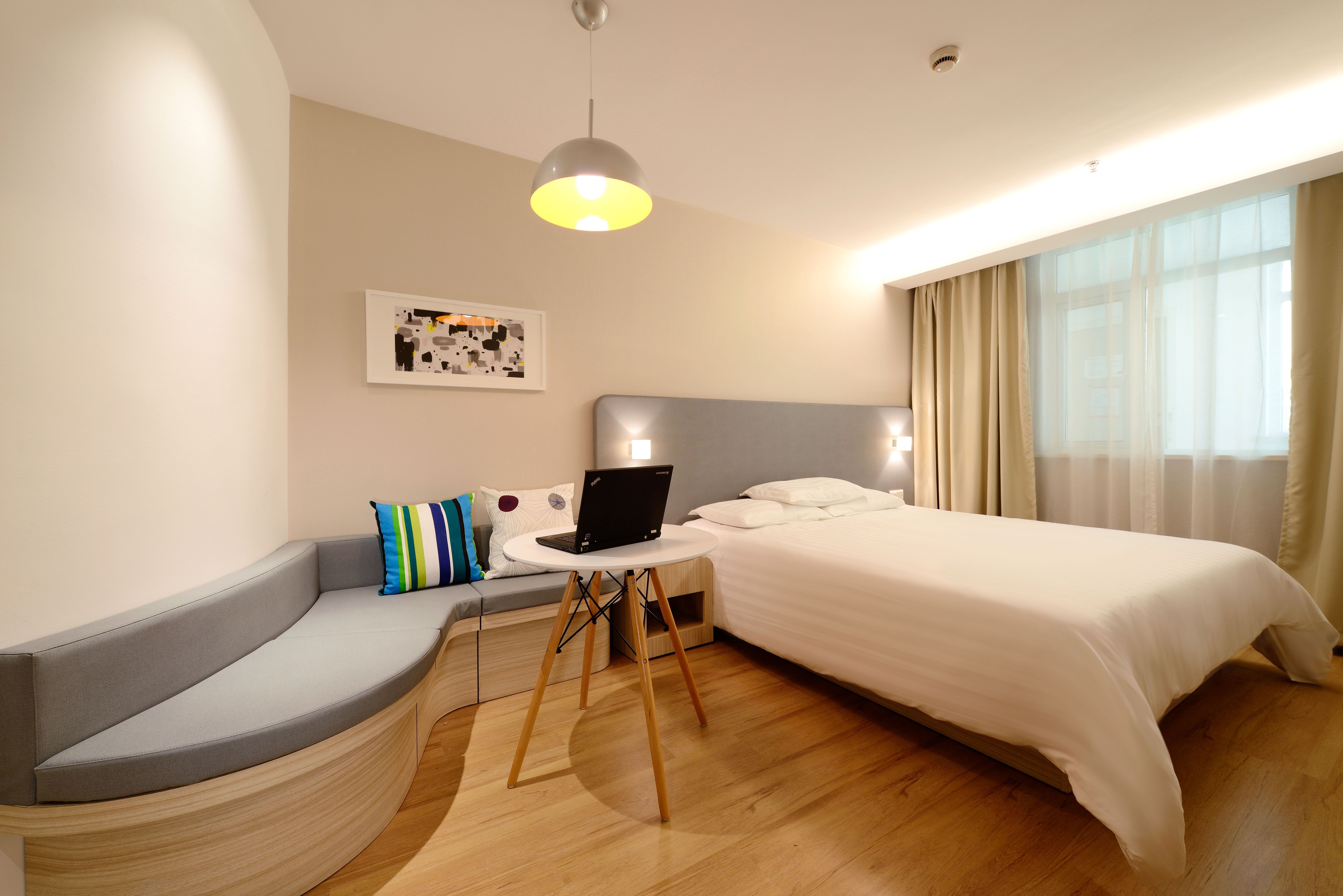 Un portátil abierto en una mesa dentro de una habitación de hotel